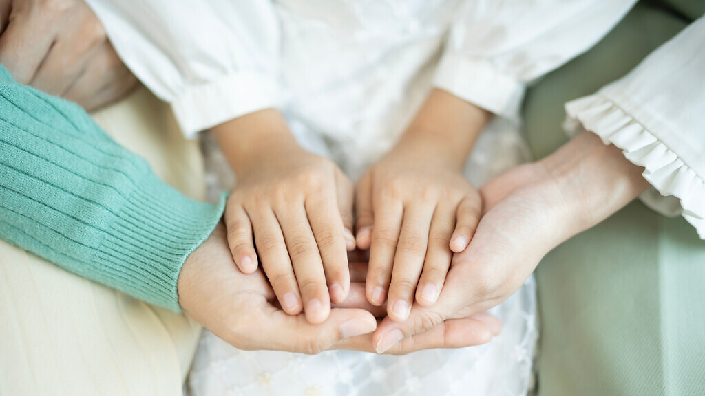 Close up of multi-generation family holding hands.