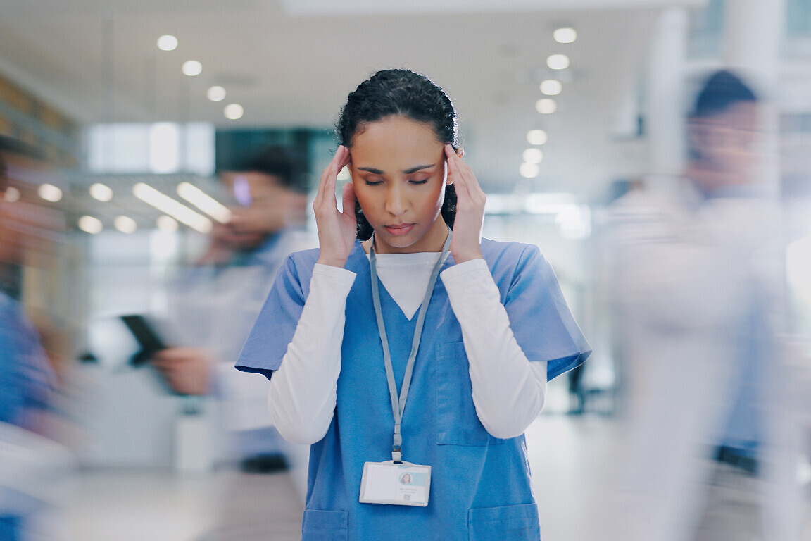 Nurse, woman and headache in hospital with stress of medical mistake, overworked and burnout. Motion blur, healthcare worker and migraine in busy clinic with fatigue, crisis and frustrated for chaos