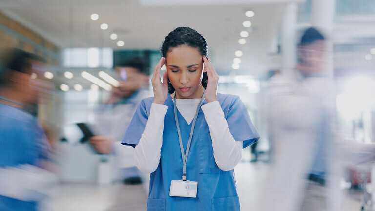 Nurse, woman and headache in hospital with stress of medical mistake, overworked and burnout. Motion blur, healthcare worker and migraine in busy clinic with fatigue, crisis and frustrated for chaos
