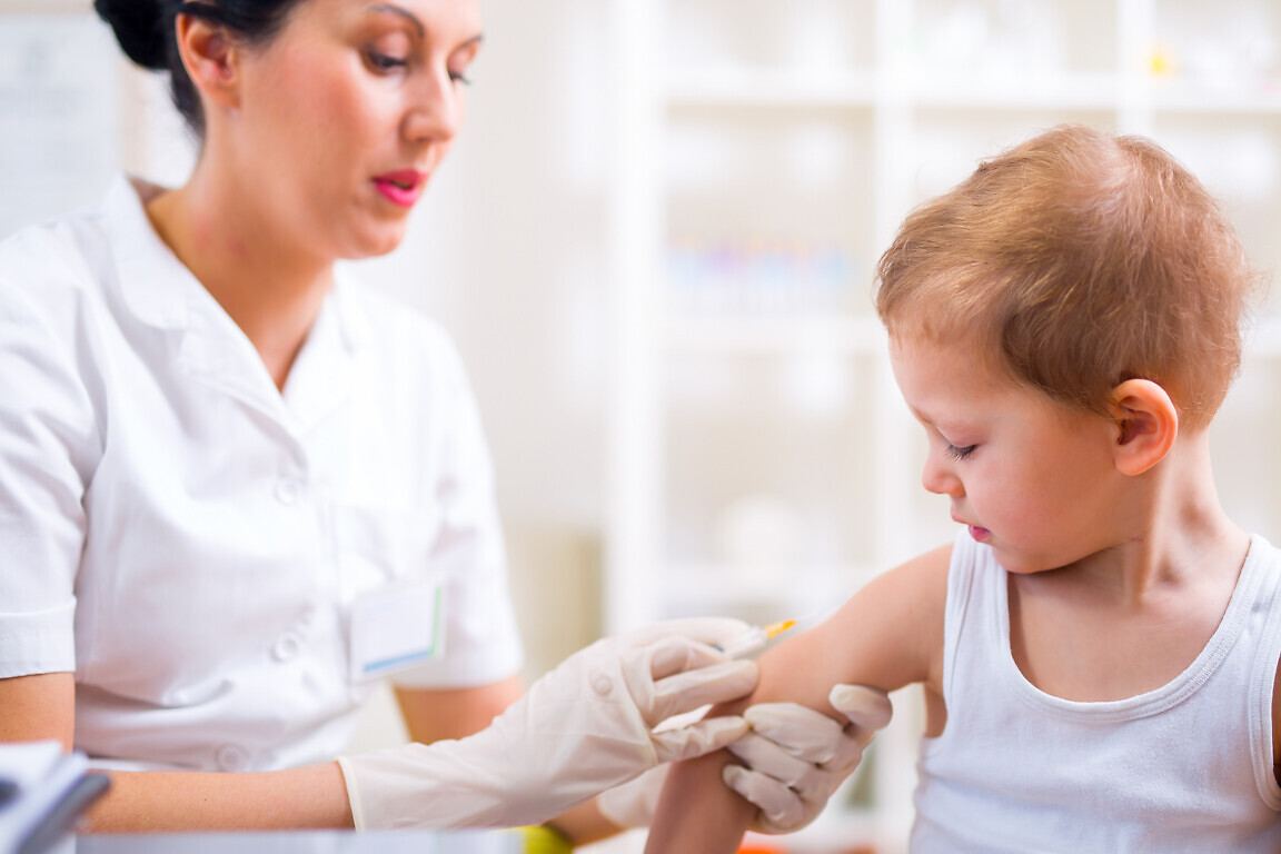 Pediatrician makes vaccination to small boy