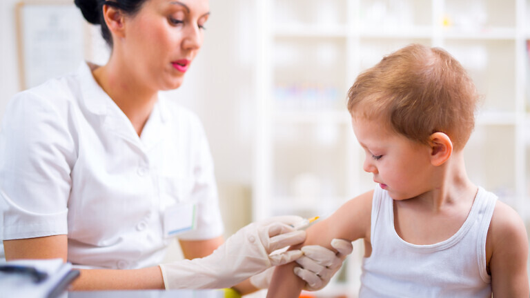 Pediatrician makes vaccination to small boy