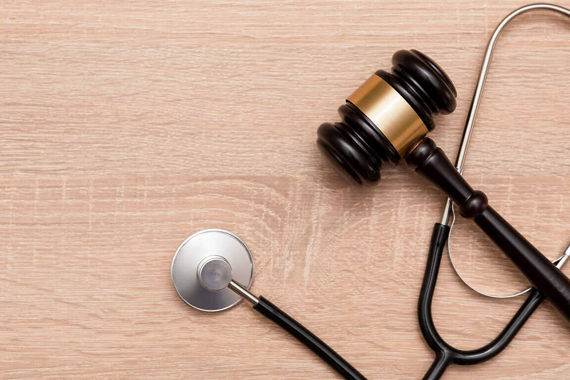 Judge gavel and stethoscope on wooden background, The law in medicine and medical negligence concept