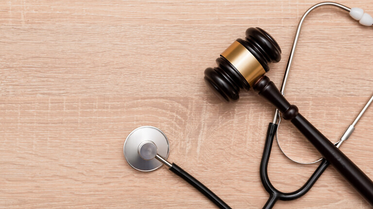 Judge gavel and stethoscope on wooden background, The law in medicine and medical negligence concept