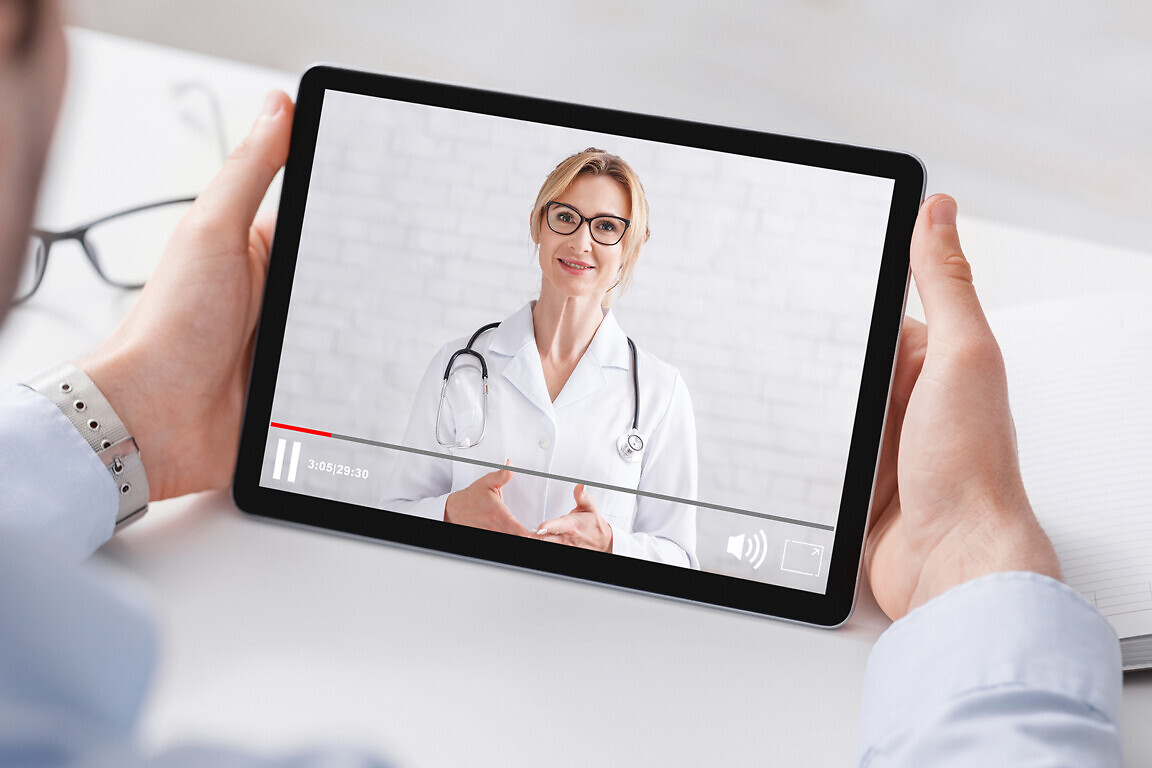 Health blog. Man in shirt watching medical video with woman doctor on tablet, panorama, free space