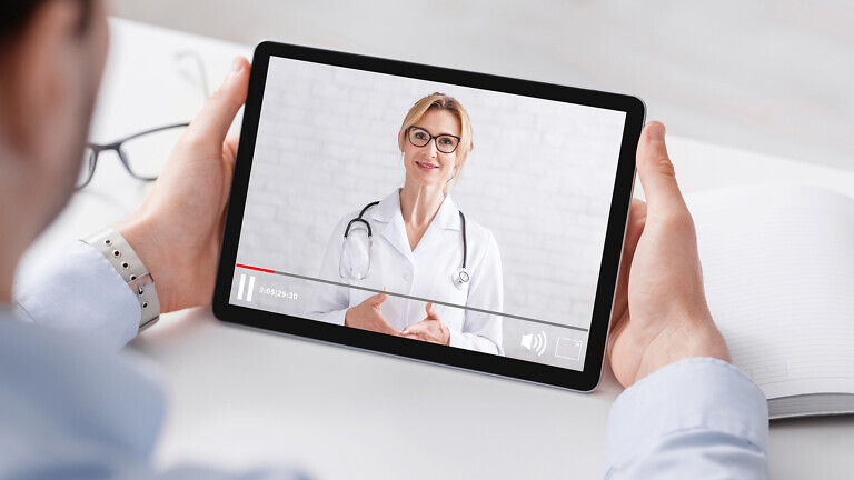 Health blog. Man in shirt watching medical video with woman doctor on tablet, panorama, free space