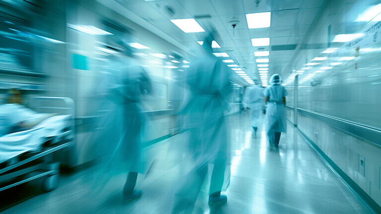 A motion blurred photograph of a hospital interior, doctor and staff working with fast movement