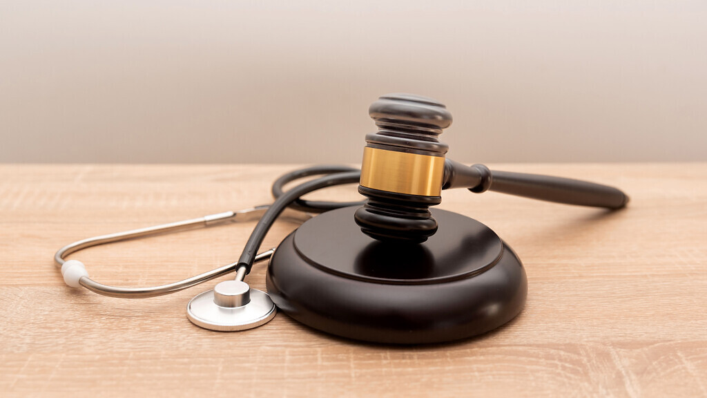 Judge gavel and stethoscope on wooden background, The law in medicine and medical negligence concept