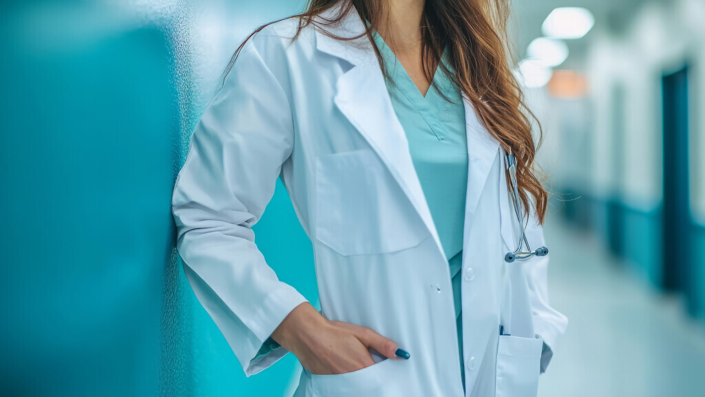 Confident female doctor standing in hospital corridor