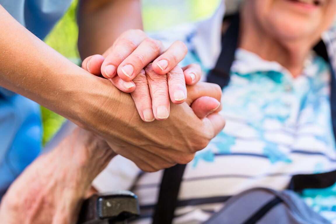 Nurse consoling senior woman holding her hand