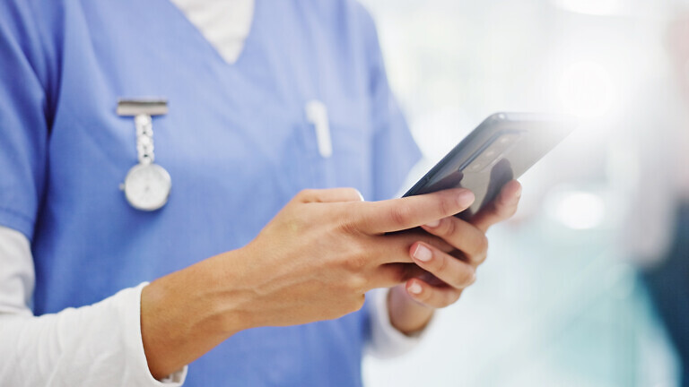 Person, hands or nurse with phone for medical research, online course or health tips at hospital. Closeup, caregiver or practitioner typing with mobile smartphone for telehealth app or news at clinic.