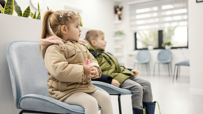 Children sitting in waiting room at hospital.
