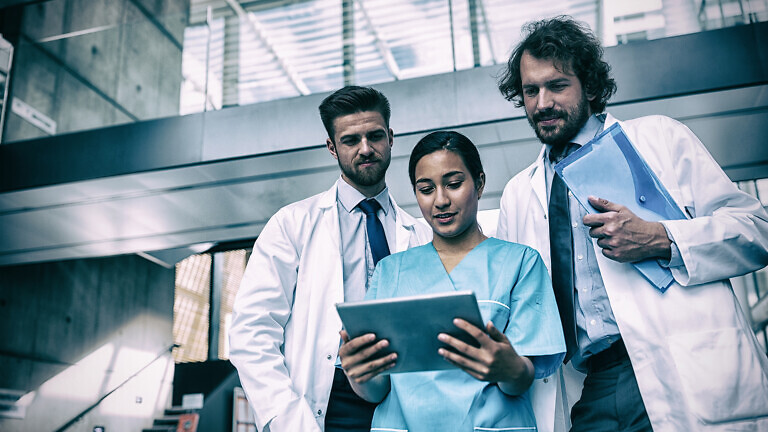 Doctors and nurse looking at digital tablet