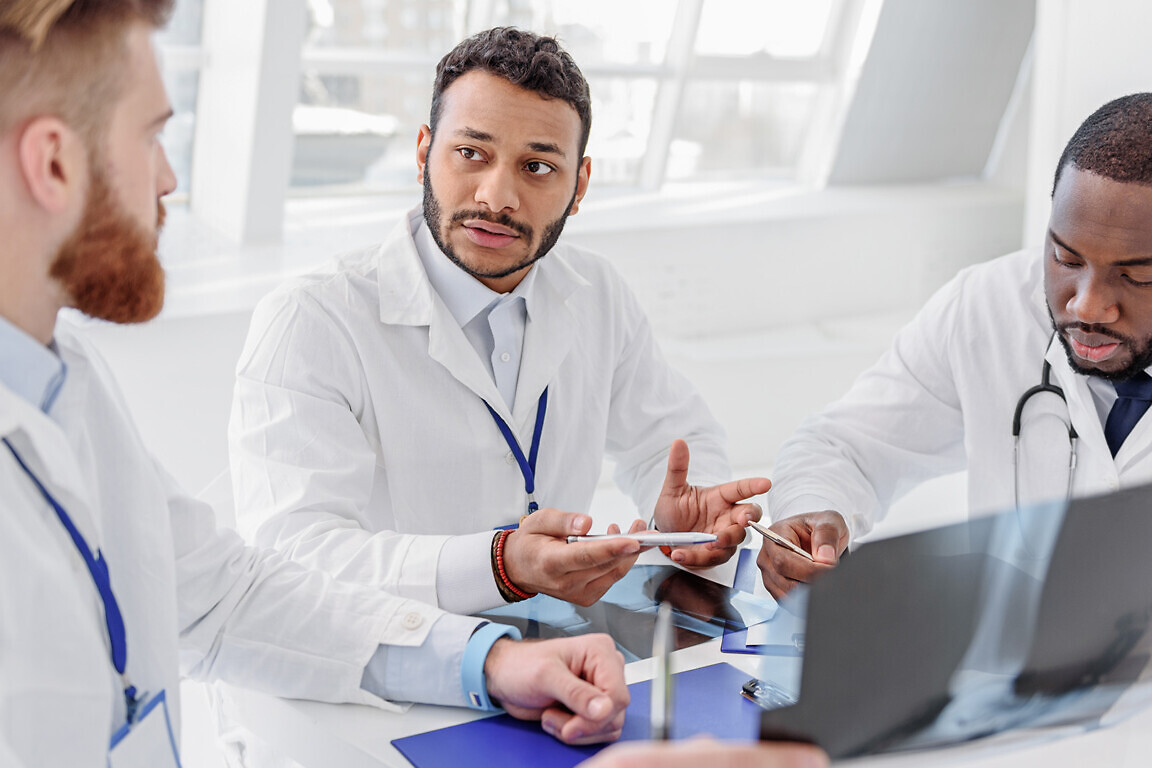 Serious doctors analyzing radiograph on council