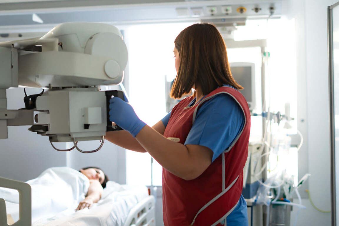 Radiologist positioning x-ray machine.
