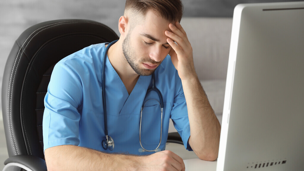 Tired medical assistant in his office