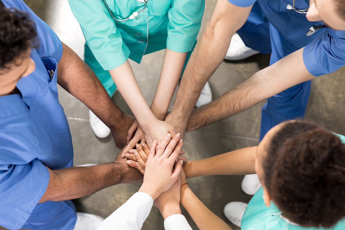 high angle view of colleagues holding hands together