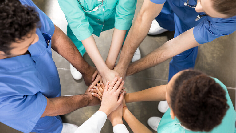 high angle view of colleagues holding hands together