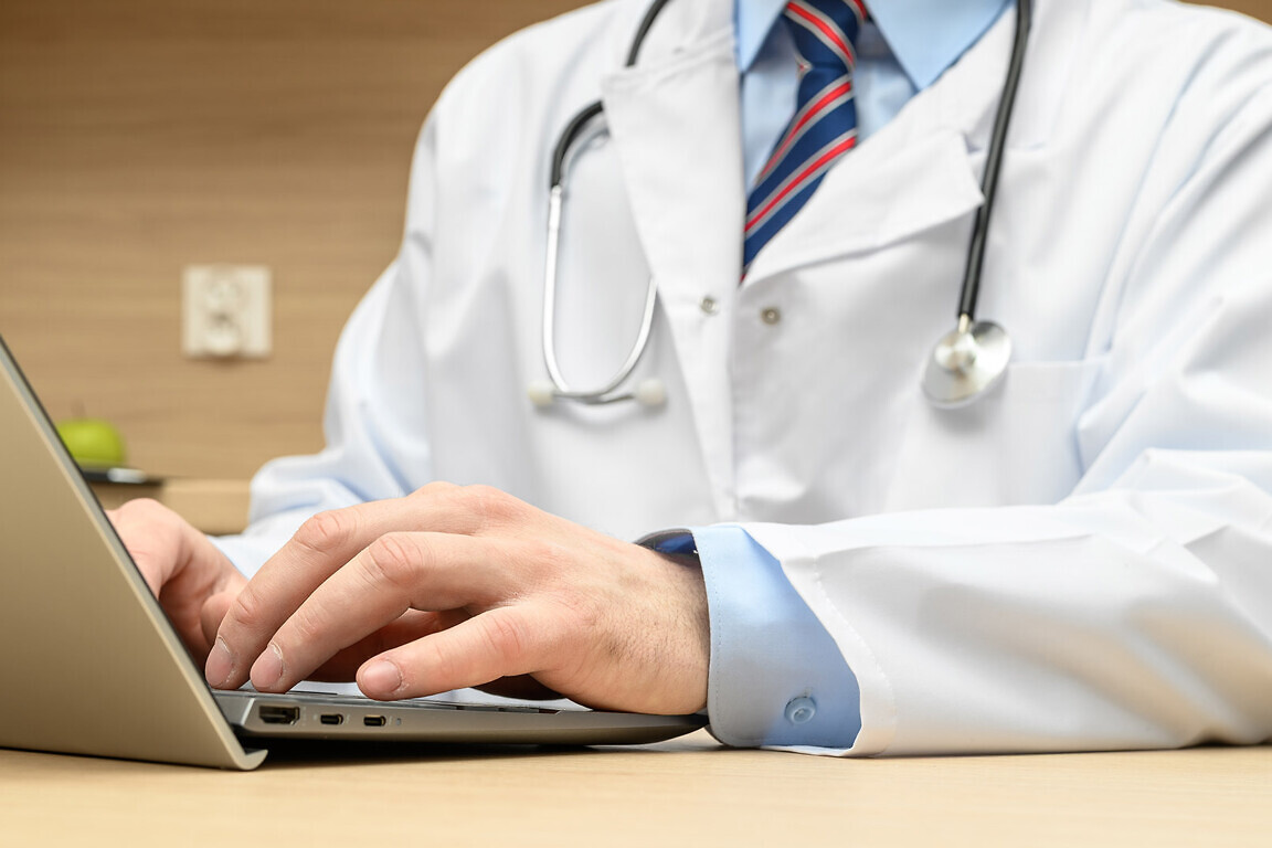 doctor working on computer, doctor in white medical coat