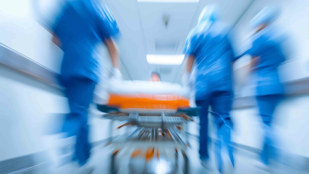 healthcare team rushing a hospital bed through corridor