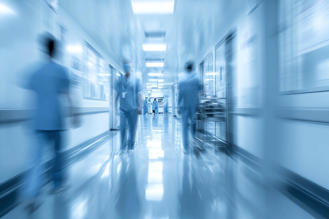 Blurred background of a hospital interior with medical equipment and people in motion Blurred hospital corridor with medical staff.