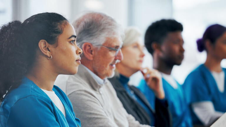 People, meeting and listening with medical team in seminar for presentation, workshop or conference. Group, employees or healthcare workers in row or line for staff training or development in clinic.