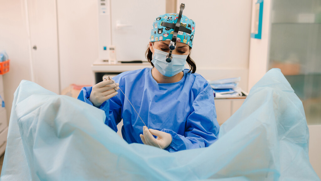 Gynecologist performs intrauterine intervention. Minimally invasive gynecological procedure using sterile instruments. Ongoing gynecological procedure in a sterile gynecology clinic
