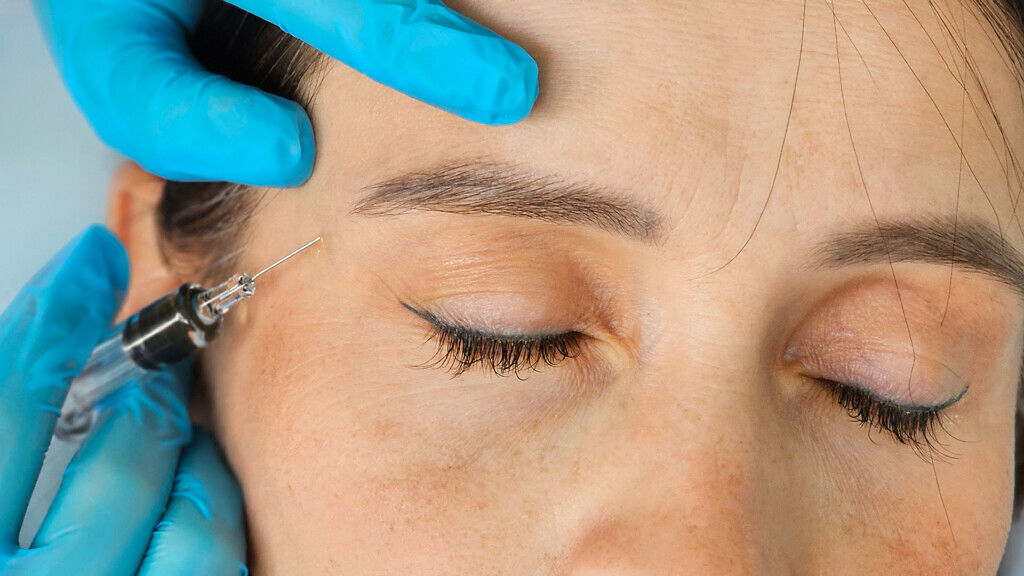 Cosmetic treatment and closeup hands of a cosmetologist making facial skin