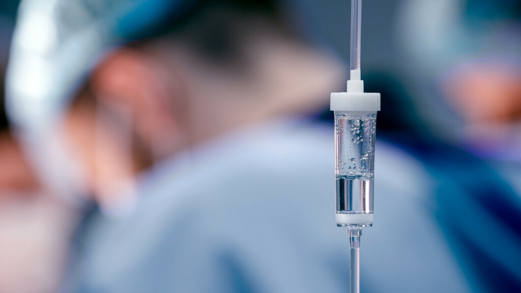 Medical IV drip with clear fluid.