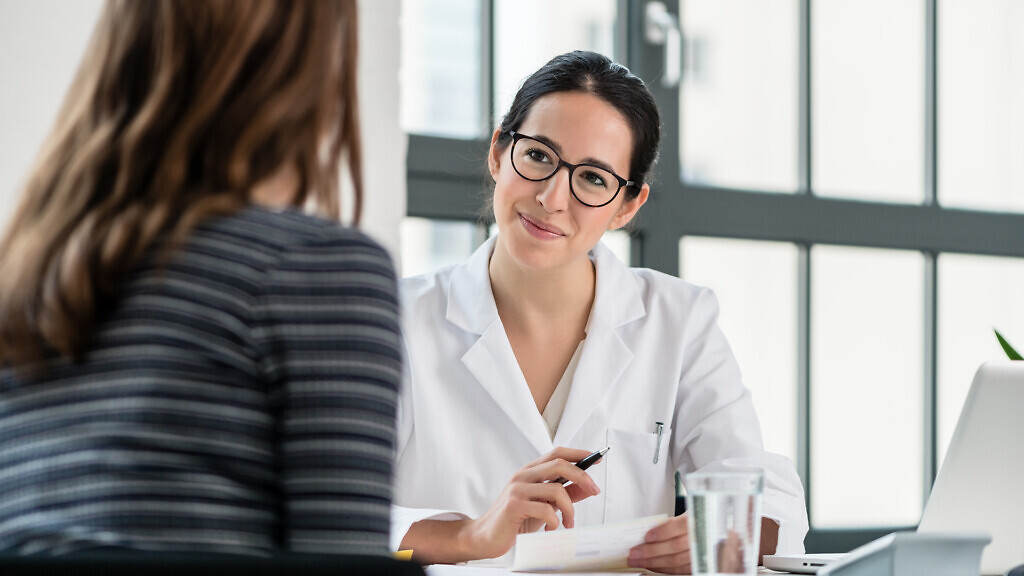 Female physician listening to her patient during consultation