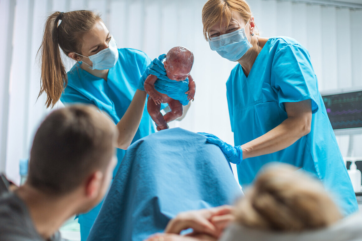 Midwife Holding Infant Baby.