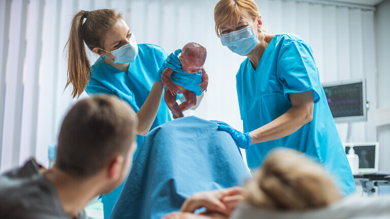 Midwife Holding Infant Baby.