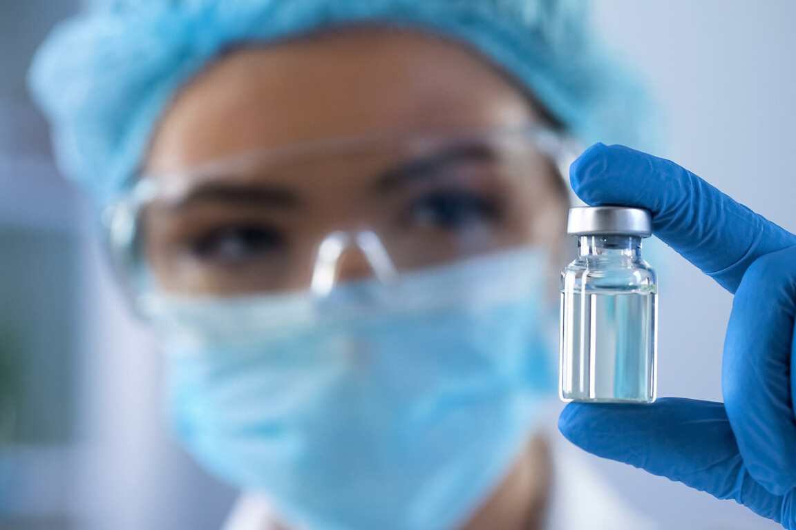 Female biologist holding bottle with new medication.