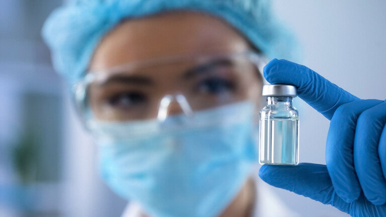 Female biologist holding bottle with new medication.