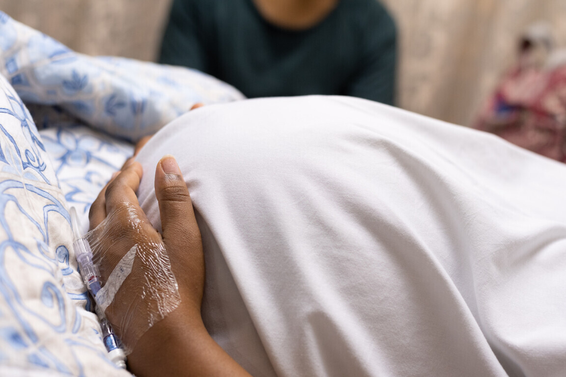 An image of a pregnant lady lying in a hospital bed.