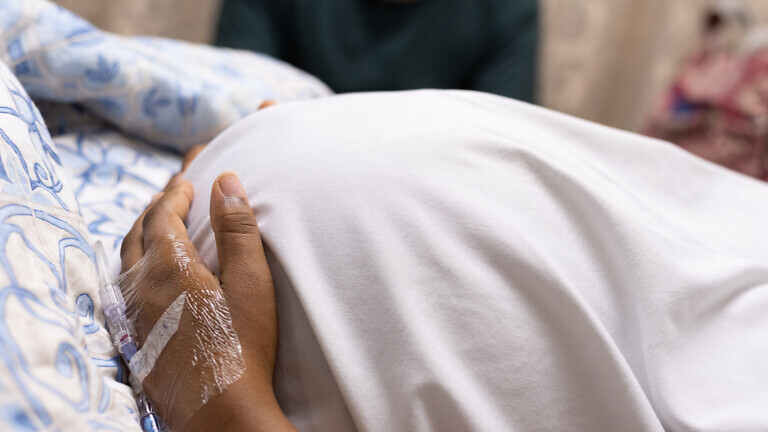 An image of a pregnant lady lying in a hospital bed.