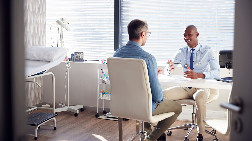 Mature Male Patient In Consultation With Doctor In Office