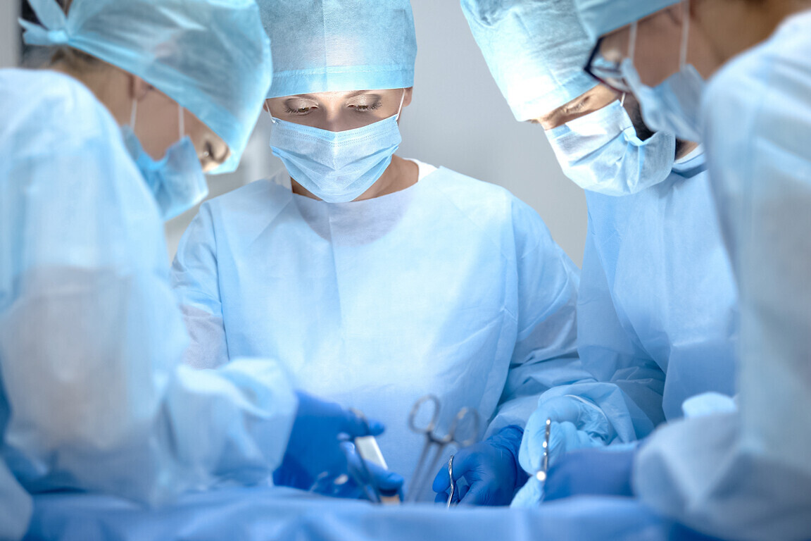Surgical operating team performing thoracic surgery in modern ho