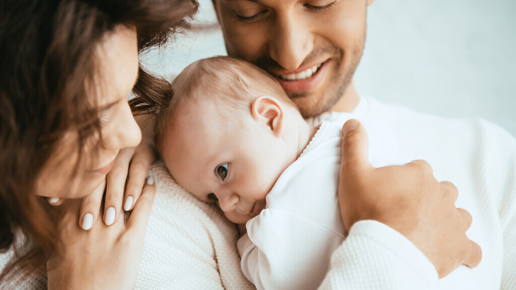 happy man holding adorable baby near smiling wife