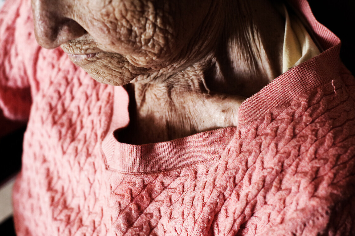 Aged woman sitting in wheelchair. wrinkle skin.