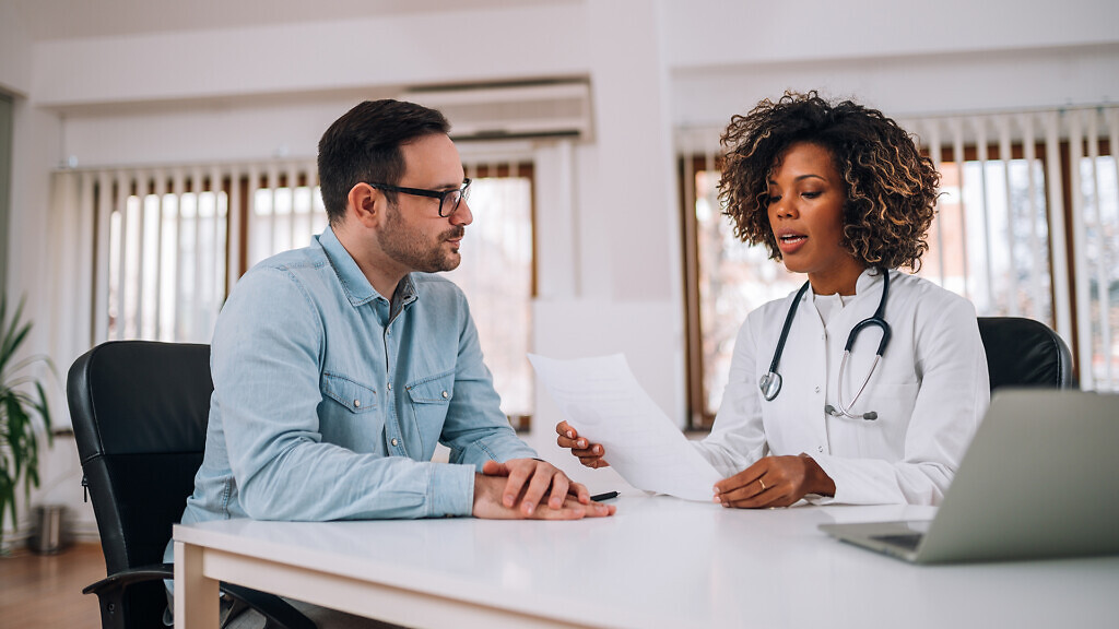 Doctor talking to a patient at medical clinic.