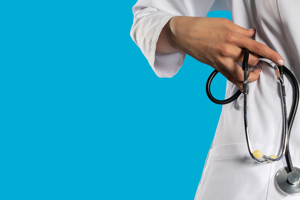 Stethoscope in a hand held by a young GP.