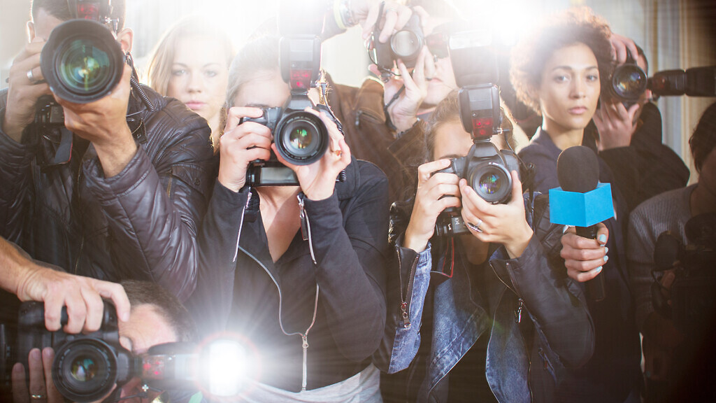 Portrait of serious paparazzi photographers pointing cameras