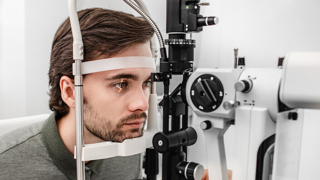 Adult man getting an eye exam at ophthalmology clinic.