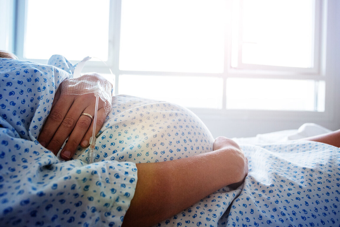 Close-up of a pregnant woman's belly in hospital