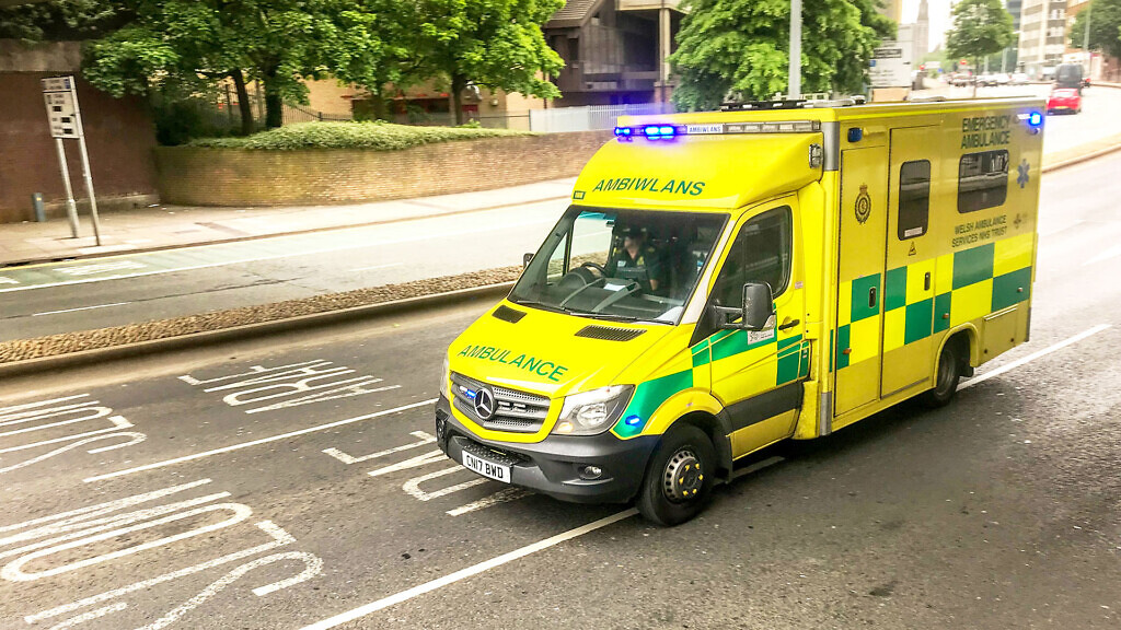 Cardiff, Wales: Ambulance driving through a city centre