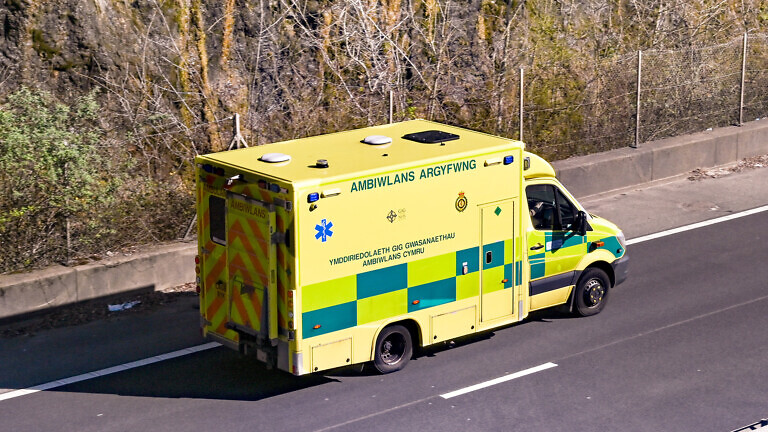 Aerial view of an ambulance driving on a dual carriageway.