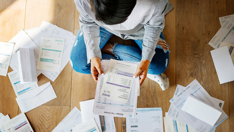 Sorting out a pile of bills on the floor