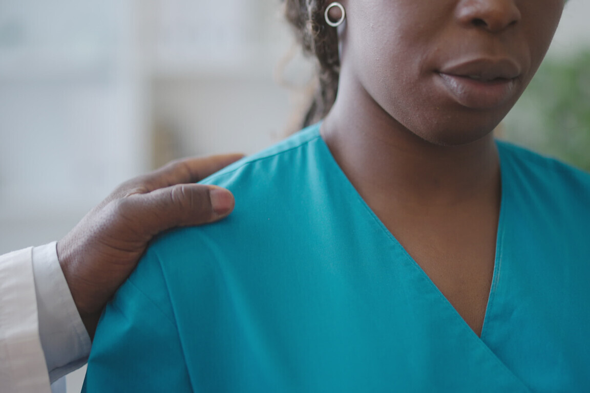 Male physician touching female colleague's shoulder