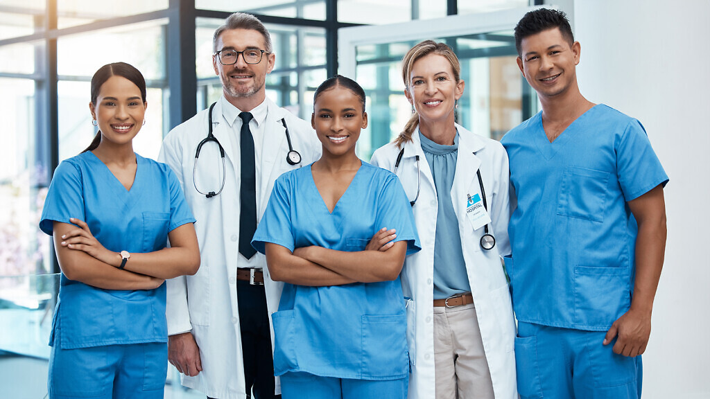 Happy doctors and nurse smile at a hospital with support, teamwork and collaboration with diversity. Team of expert medical professionals smiling at work together at clinic in the healthcare industry