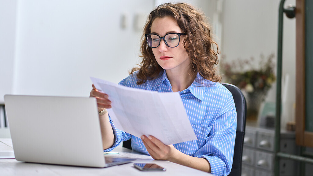 Doctor Using Spreadsheet For Billing Codes On Desktop